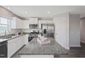 Modern kitchen featuring white cabinets, granite countertops, and stainless steel appliances at 37 Artesa Ct, Fuquay Varina, NC 27526