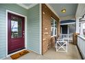 View of a covered front porch with brick accents, seating, and a welcoming 'hello' doormat at 376 Granite Mill Blvd, Chapel Hill, NC 27516