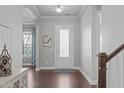 Inviting foyer with hardwood floors, white trim, arched openings, and a view of staircase and living spaces at 4117 Bluff Oak Drive Dr, Cary, NC 27519
