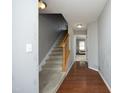 Hallway with wood floors and carpet stairs that lead to upstairs rooms with abundant natural light at 4905 Briarstone Ct, Raleigh, NC 27610