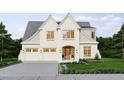 Charming two-story home with white painted brick, an attached three-car garage, and beautifully landscaped yard at 525 Peebles St, Raleigh, NC 27608