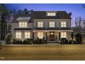 Attractive home with a well-lit front exterior at dusk, highlighting the inviting entrance and landscaped yard at 5600 Abbey Grace Ln, Wake Forest, NC 27587