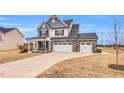 Charming two-story home boasting a three-car garage and covered front porch with rocking chairs at 59 N Clearbrook Ct, Angier, NC 27501