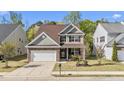 Beautiful two-story home with a manicured lawn, stone accents, and attached garage, bathed in natural light at 69 Florence Dr, Clayton, NC 27527