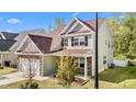 Inviting two-story home with an attached garage and well-maintained lawn, showcasing its pleasant curb appeal at 69 Florence Dr, Clayton, NC 27527