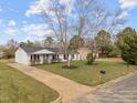 Aerial view of a cozy home with a well-manicured lawn, surrounded by mature trees and a welcoming driveway at 711 Wheat Mill Rd, Durham, NC 27704