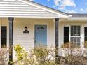 Close-up showcasing a light blue front door with glass detail, set against white siding and black shutter accents at 711 Wheat Mill Rd, Durham, NC 27704