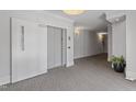 Well lit interior hallway with carpet, an elevator, a potted plant, and sconces on the wall at 714 Waterford Lake Dr, Cary, NC 27519