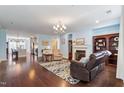 Open-concept living room with fireplace, hardwood floors, comfortable seating and decorative rug at 714 Waterford Lake Dr, Cary, NC 27519