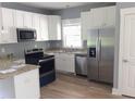 Modern kitchen with stainless steel appliances, white cabinets, and granite countertops at 8 Elaine Cir, Durham, NC 27703