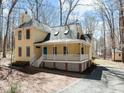 Charming two-story home with yellow siding, a welcoming front porch, and a well-maintained yard at 8111 Reynard Rd, Chapel Hill, NC 27516