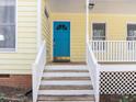 Close-up of the front door with a blue door, white stairs, and well-maintained exterior at 8111 Reynard Rd, Chapel Hill, NC 27516