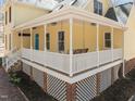Inviting front porch with a porch swing, white railings, and yellow siding, creating a cozy outdoor space at 8111 Reynard Rd, Chapel Hill, NC 27516