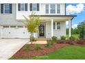 Charming home exterior showcasing a well-manicured lawn, mulch flower beds, and a covered front door entrance at 8729 Maxine St # 38, Willow Springs, NC 27592