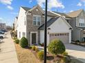 Attractive townhome exterior featuring a two-car garage, manicured lawn, and inviting front entrance at 1003 Mirbeck Ln, Durham, NC 27713