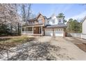 Stately two-story home with a brick facade, inviting front porch, and a spacious three-car garage at 101 Palmwood Ct, Cary, NC 27519