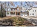 Charming two-story brick home with a covered porch and a three-car garage, surrounded by blossoming trees at 101 Palmwood Ct, Cary, NC 27519