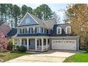 Two-story home with blue siding, a covered front porch, and an attached two-car garage at 104 Stenness Ct, Apex, NC 27502