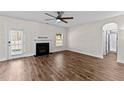 Open-concept living room featuring hardwood floors, a ceiling fan, and a fireplace at 104 Vinewood Pl, Holly Springs, NC 27540
