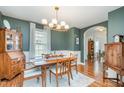 Elegant dining room with a wooden table, decorative lighting fixture, and view to living area at 1044 S Philwood Ct, Fuquay Varina, NC 27526