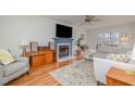 Bright living room featuring a cozy fireplace, ceiling fan, and a comfortable seating area with lots of light at 1044 S Philwood Ct, Fuquay Varina, NC 27526