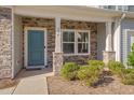 Inviting front porch featuring stone columns, stylish blue door, and tasteful landscaping at 106 Florence Pl, Morrisville, NC 27560
