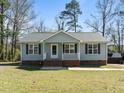 Charming single-story home with light blue siding, black shutters, and a cozy front porch at 117 Holly Mountain Rd, Holly Springs, NC 27540