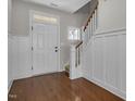 Elegant entryway boasting hardwood floors, wainscoting, and a staircase creating a welcoming ambiance at 127 Station Dr, Morrisville, NC 27560