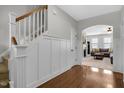 Bright foyer featuring hardwood floors, white wainscoting, and a staircase leading to the upper level at 127 Station Dr, Morrisville, NC 27560