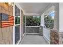 Cozy porch area with decorative stone supports, ample light, and American flag detail at 1416 Endgame Ct, Wake Forest, NC 27587