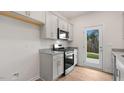 Kitchen featuring granite countertops, gray cabinets, stainless steel appliances, and a view to the outdoors at 172 Starlight St, Sanford, NC 27330