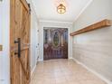 Inviting entryway with a decorative wood door, tile flooring, and a rustic sliding barn door feature at 18 Five Ponds Dr, Sanford, NC 27332