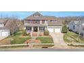 Stunning exterior of a two-story house featuring a well-manicured lawn, covered porch, and a three-car garage at 2015 Stanchion St, Haw River, NC 27258