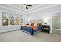 Bright main bedroom with tray ceiling, large windows, and a luxuriously appointed ensuite bathroom at 2046 Fellini Dr, Apex, NC 27502