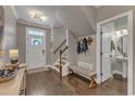 Welcoming foyer featuring a bench, staircase, and a view into a half bathroom at 205 Virginia Water Dr, Rolesville, NC 27571