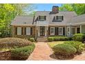 A beautiful brick home with black shutters and door, and a brick walkway lined with greenery at 2140 N Lakeshore Dr, Chapel Hill, NC 27514