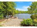 Scenic lakeside view with cozy seating around a stone fire pit at 2140 N Lakeshore Dr, Chapel Hill, NC 27514