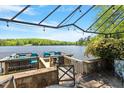 Waterfront patio area with stone retaining wall and outdoor furniture at 2140 N Lakeshore Dr, Chapel Hill, NC 27514