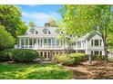 Charming home features a sunroom, white trim windows, and professionally landscaped yard at 2140 N Lakeshore Dr, Chapel Hill, NC 27514