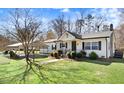 View of home showcasing maintained lawn, covered carport, and mature tree at 2246 Arrowhead Rd, Dunn, NC 28334