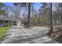 Gravel driveway leading to the home, with mature trees in the background at 2312 Valley Rd, Sanford, NC 27330