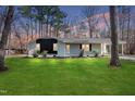 Inviting home featuring a well-manicured lawn and cozy exterior lighting at dusk at 2312 Valley Rd, Sanford, NC 27330