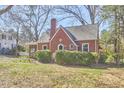 Charming brick home featuring mature landscaping and a chimney at 2313 Prince St, Durham, NC 27707