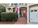 Inviting front porch featuring brick steps, white columns, and a vibrant red front door at 233 Candia Ln, Cary, NC 27519