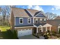 Charming two-story home with a covered front porch, brick and stone accents, and a well-manicured front yard at 234 Macallan Dr, Burlington, NC 27215