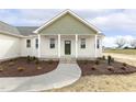 Charming home featuring covered porch with crisp white columns and a classic olive-green front door at 239 Surles Rd, Benson, NC 27504