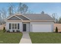 Inviting single-story home with a well-manicured lawn, neutral siding, and a two-car garage at 274 Deodora Ln, Cameron, NC 28326