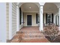 Charming front porch features brick flooring, white columns, and space for outdoor seating at 2803 Cameron Pond Dr, Cary, NC 27519