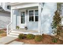 Inviting front porch with a white door, flower planters, and manicured landscaping at 2816 Cascadilla St, Durham, NC 27704