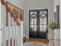 Inviting entryway with double glass doors, wood floors, and an elegant tapestry at 2826 Walden Rd, Apex, NC 27502